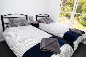 two beds in a room with a window at Warburton Digs in Warburton