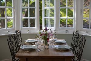 a wooden table with chairs and a vase of flowers on it at Saltmarsh Farmhouse in West Dean
