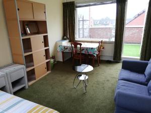 a room with a bed and a table and a couch at Homestay Utrecht in Utrecht