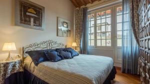 ein Schlafzimmer mit einem Bett mit blauen Kissen darauf in der Unterkunft Al Campanile in Florenz