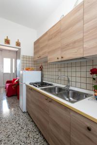 a kitchen with wooden cabinets and a sink and a refrigerator at Appartamenti Bedin, JESOLO LIDO in Lido di Jesolo