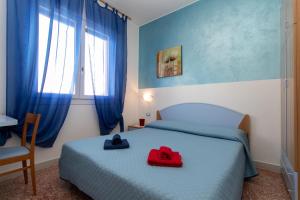 una camera da letto con un letto con due cappelli sopra di Appartamenti Bedin, JESOLO LIDO a Lido di Jesolo