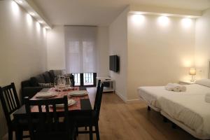 a room with a dining table and a bed at Puente Romano by Salamancavacacional in Salamanca