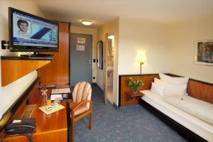 ein Hotelzimmer mit einem Bett und einem Flachbild-TV in der Unterkunft Advantage Appartements Hotel in Nürnberg