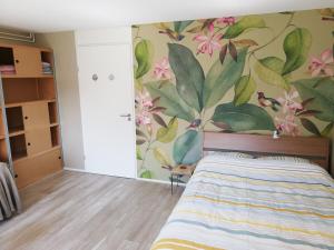 a bedroom with a mural of flowers on the wall at Homestay Utrecht in Utrecht