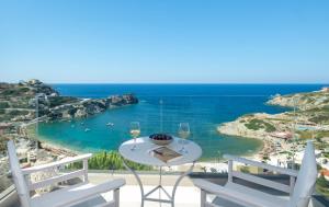 a table with wine glasses and a view of the ocean at Villa Ligaria, Lygaria in Agia Pelagia