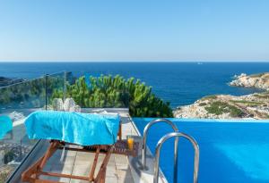 a table and chairs on a balcony with a view of the ocean at Villa Ligaria, Lygaria in Agia Pelagia