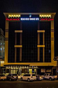 a large building with cars parked in front of it at Dreams Houses furnished Suites in Tabuk