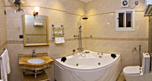 a bathroom with a tub and a toilet and a sink at Dreams Houses furnished Suites in Tabuk