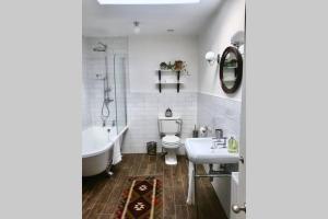 a bathroom with a tub and a toilet and a sink at The Terrace in Cheltenham