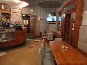 een restaurant met een tafel en stoelen en een bar bij Albergo Baschera in Fagagna