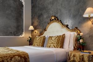 una camera da letto con un grande letto bianco con golosità di Hotel Pausania a Venezia