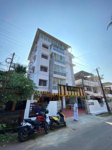 门格洛尔Hotel Sharda Residency的两辆摩托车停在一栋建筑物前