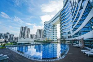 um grande edifício com uma piscina em frente a uma cidade em Wyndham Grand Plaza Royale Xiamen - Wuyuan Bayview em Xiamen
