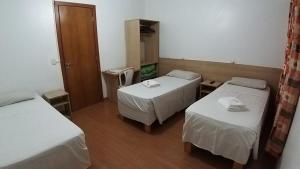 a room with two beds and a mirror at Hotel Pousada Sinos in São Leopoldo