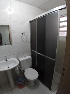 a bathroom with a shower and a toilet and a sink at Hotel Pousada Sinos in São Leopoldo
