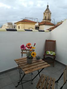 una mesa con flores en la parte superior de un balcón en Apartamentos El Marques, en Málaga