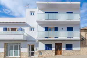 a white building with blue windows and doors at Port Apartments in Port d'Alcudia