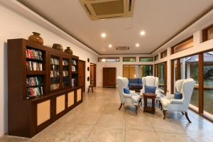 a living room with a table and chairs and bookshelves at Serene Pavilions in Wadduwa