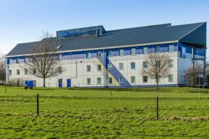 a large white building with a black roof in a field at ibis budget Düsseldorf Airport in Ratingen