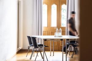 a dining room with a white table and chairs at ODELYA - Stadthotel im Park in Basel