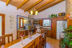 a kitchen with a long table and wooden cabinets at Finca SA ROTA in Ariany