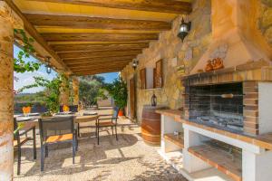an outdoor patio with a fireplace and a table and chairs at Finca SA ROTA in Ariany