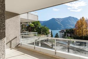 a balcony with a view of the water and mountains at Maraini 15 by Quokka 360 - bright flat with lake view in Lugano