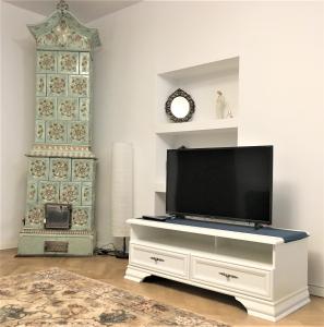 a living room with a television on a white dresser at White Wolf Apartment in Braşov