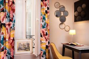 une pièce avec une table, une chaise et une fenêtre dans l'établissement Hôtel des Arts Montmartre, à Paris