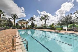 a large swimming pool with a gazebo and palm trees at Luxury 3BR Reunion Resort Condo Near Disney Golf & Pools in Kissimmee