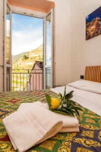 a bedroom with a bed with a towel and a window at Casa Di Mezzo by Arbaspàa in Manarola