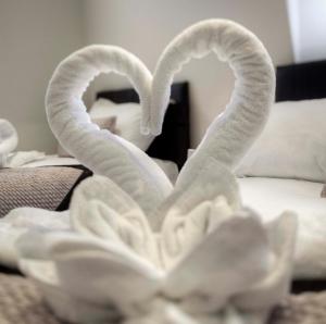 - deux serviettes de toilette en forme de cœur sur un lit dans l'établissement NOX Belsize Park, à Londres