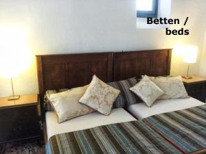 a bedroom with a bed with pillows and two lamps at Ferienwohnung VISHWAS in Trier
