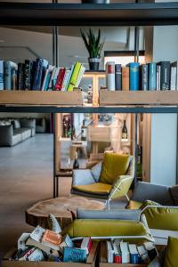 a room with shelves filled with books and a chair at Golfo del Sole Hotel & Holiday Resort in Follonica