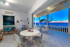 a room with a balcony with a table and chairs at Monolithi Seaside Cottage in Kanali