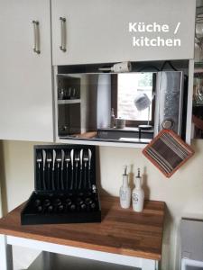 a kitchen with a counter with bottles and a microwave at Ferienwohnung VISHWAS in Trier +16 photos