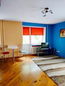 sala de estar con paredes azules, mesa y sillas en "центр Ж/Д" en Rivne