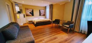 ハンブルクにあるPark Hotel Hamburg Arenaのベッドとソファと椅子のある寝室 +23枚の写真