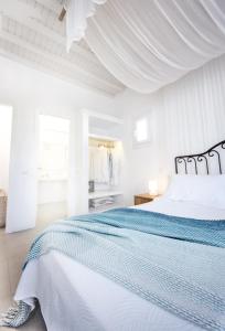 Biała sypialnia z 2 łóżkami i białym sufitem w obiekcie Agnandi Cielo w mieście Tourlos