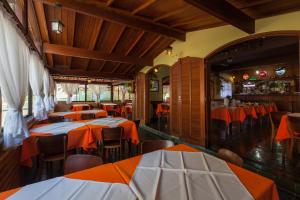 a restaurant with tables and chairs with orange and white tables at Pousada Zero Grau in Nova Friburgo