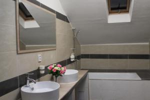 a bathroom with two sinks and a bath tub at Pension TV in Planá