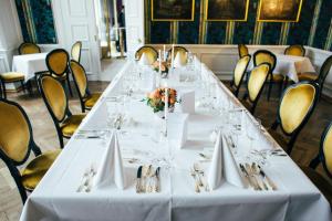 a long white table with glasses and napkins at Hotel Schloss Wilkinghege in Münster
