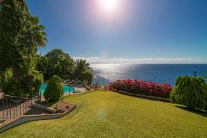 a large yard with a view of the ocean at Villa Albatroz in Caniço