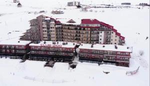 a large building in the snow with snow on it at Megre Sweet Home in Gudauri