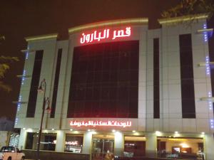 un edificio con un cartel encima por la noche en Baron Palace - AlMasif hotel apartments, en Riad