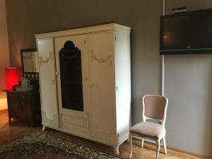 Guest House Anna Caffe في Bezdan: خزانة وكرسي في غرفة