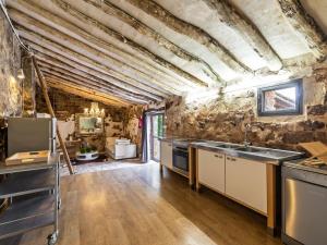 a large kitchen with a stone wall and wooden floors at Belvilla by OYO Cottage Fraga in Torrente de Cinca