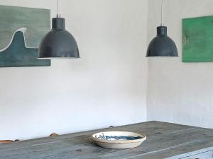duas luzes por cima de uma mesa de madeira com uma tigela em 2 person holiday home in Gilleleje em Gilleleje