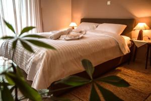 sypialnia z białym łóżkiem z 2 lampami i rośliną w obiekcie API Projects Nafplio - Family Superior Apartment w Nauplionie